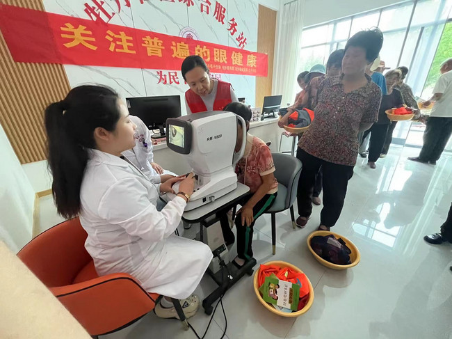 图为医务人员为居民做视力检查.jpg