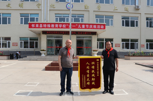县残联开展“六一”儿童节特殊教育学校慰问活动，校长向残联赠予锦旗（摄影：柴志霞）.jpg