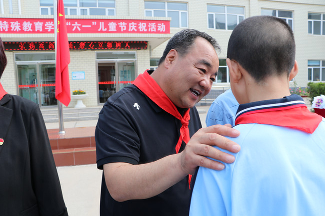 县残联理事长王孝国亲切地与残疾学生交谈（摄影：柴志霞）.jpg